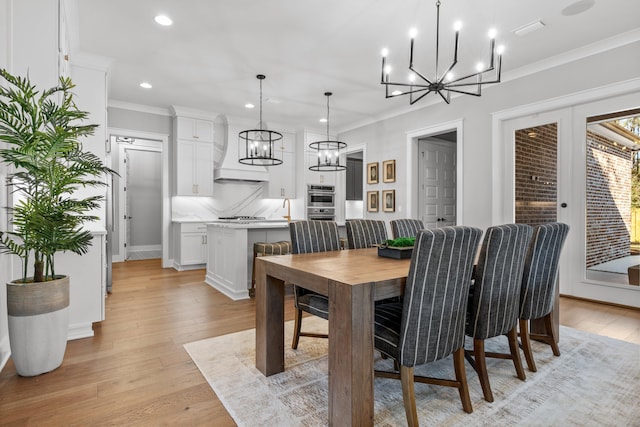 dining area with light hardwood / wood-style flooring and ornamental molding