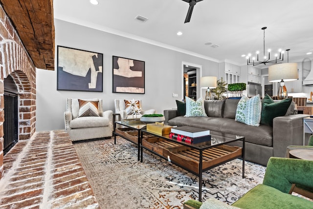 living room featuring ceiling fan with notable chandelier, ornamental molding, and a fireplace