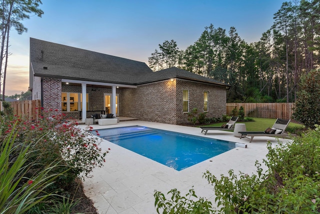 pool at dusk with a patio