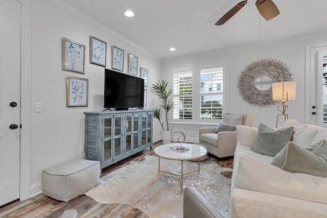 living room featuring hardwood / wood-style floors, ceiling fan, and crown molding