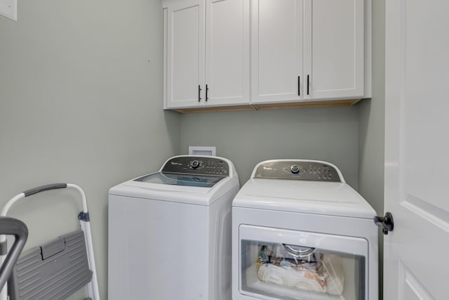 washroom with washing machine and dryer and cabinets