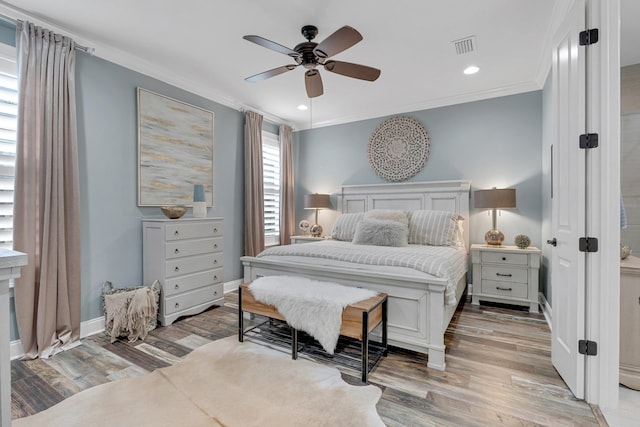 bedroom with hardwood / wood-style floors, ceiling fan, and crown molding