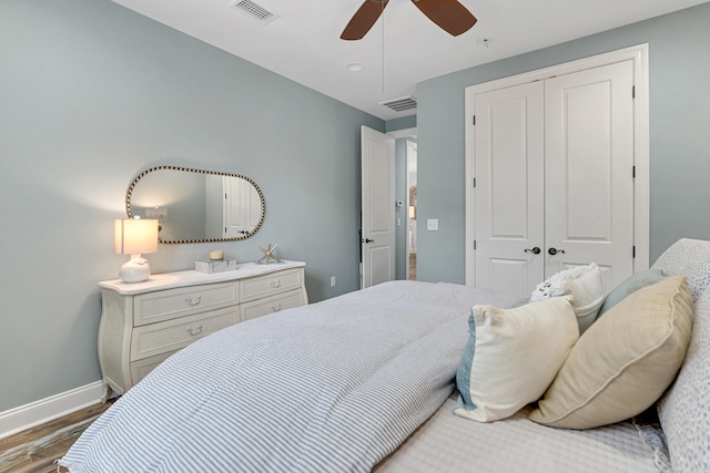 bedroom with dark hardwood / wood-style flooring, ceiling fan, and a closet