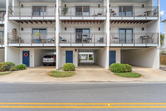 view of apartment building / complex with a carport and driveway