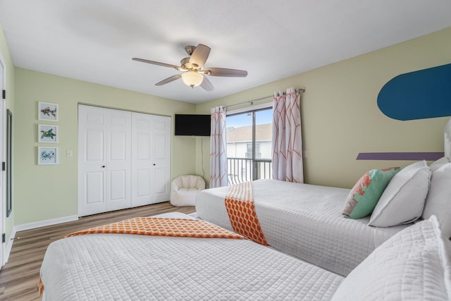 bedroom with wood finished floors, a closet, a ceiling fan, and baseboards