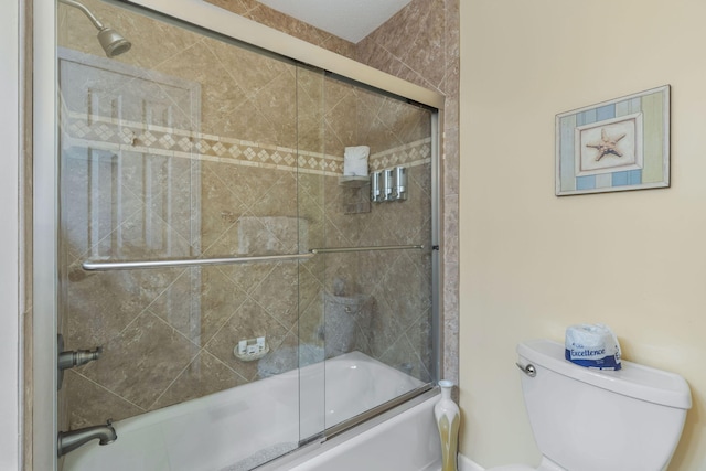 full bath featuring combined bath / shower with glass door and toilet