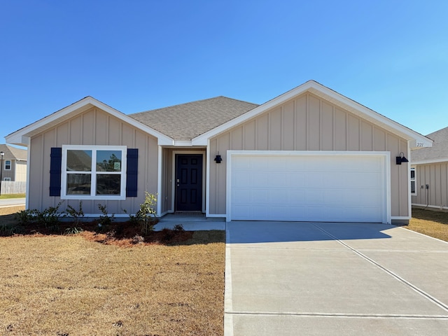 single story home featuring a shingled roof, concrete driveway, an attached garage, board and batten siding, and a front yard