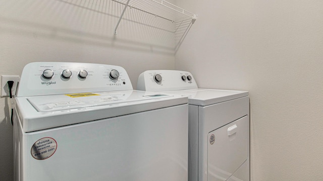 clothes washing area with washer and clothes dryer