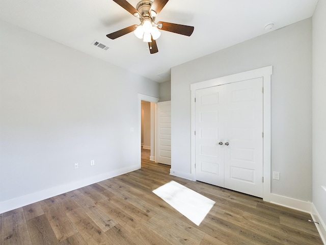 unfurnished bedroom with ceiling fan, hardwood / wood-style floors, and a closet