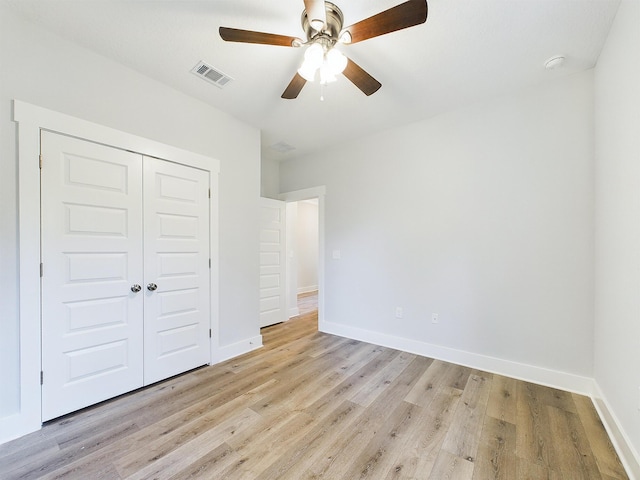 unfurnished bedroom featuring ceiling fan, light hardwood / wood-style floors, and a closet