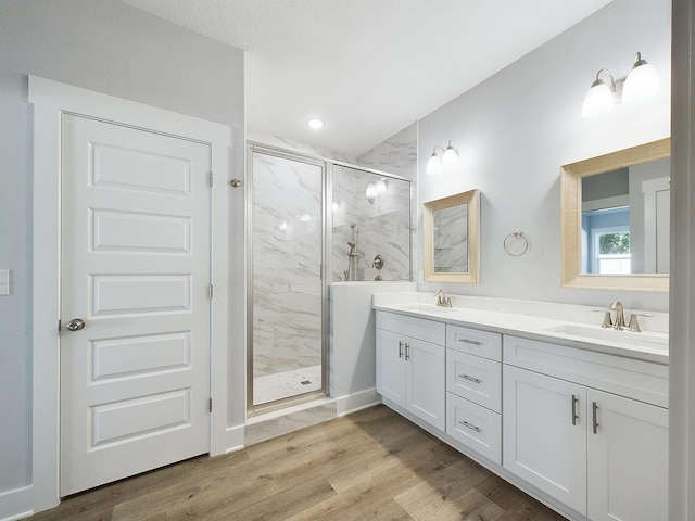 bathroom with hardwood / wood-style flooring, an enclosed shower, and vanity