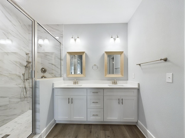 bathroom with wood-type flooring, a shower with door, and vanity