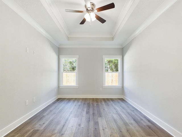 spare room with crown molding, light hardwood / wood-style floors, ceiling fan, and a raised ceiling