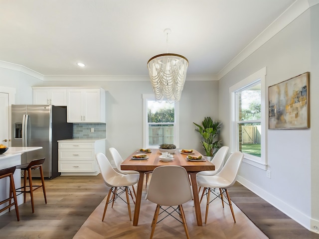 dining space with an inviting chandelier, dark hardwood / wood-style flooring, and crown molding