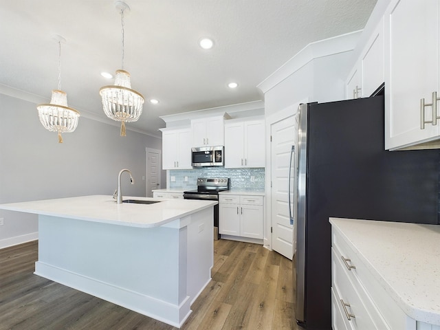 kitchen with sink, a kitchen island with sink, appliances with stainless steel finishes, and crown molding