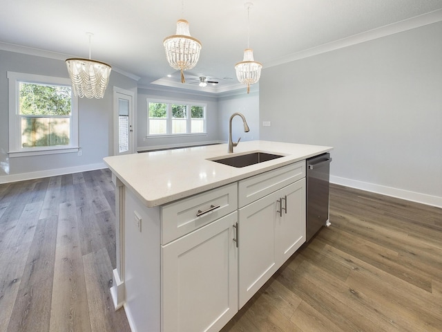 kitchen featuring dishwasher, sink, white cabinets, decorative light fixtures, and an island with sink