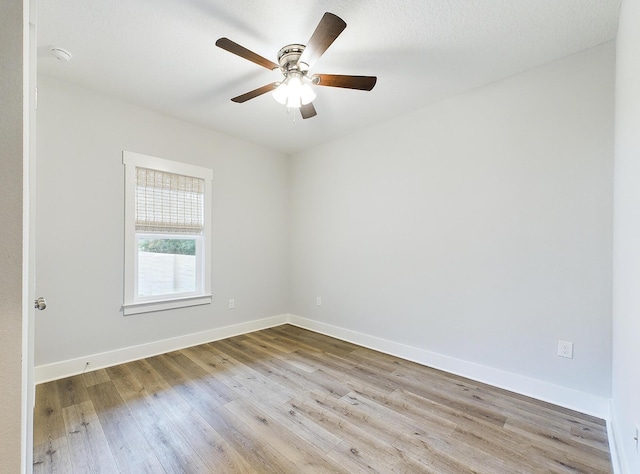 spare room with ceiling fan, wood finished floors, and baseboards