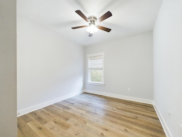 empty room featuring light wood finished floors, ceiling fan, baseboards, and a textured ceiling