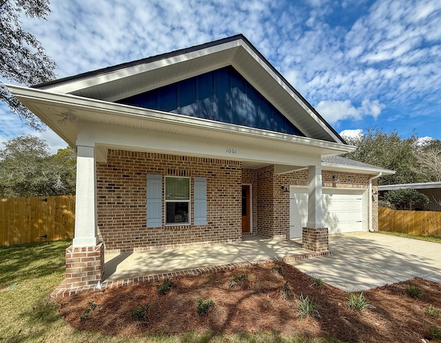 craftsman-style home with driveway, brick siding, an attached garage, and fence