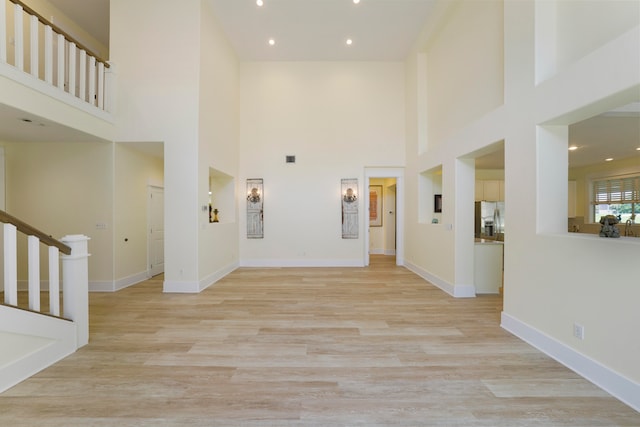 interior space featuring a high ceiling and light hardwood / wood-style floors