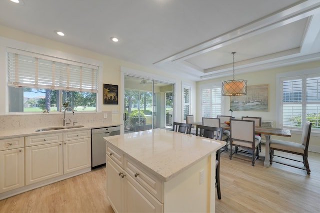 kitchen featuring a kitchen island, light wood-type flooring, pendant lighting, sink, and dishwasher