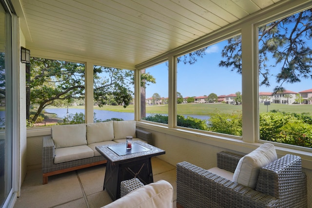 sunroom featuring a water view