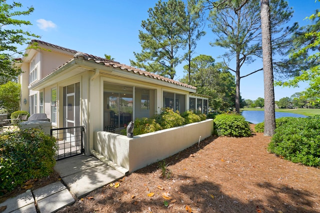 view of home's exterior with a sunroom