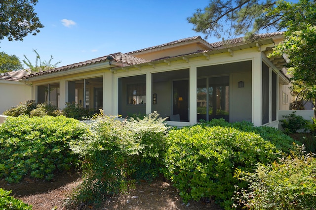 rear view of property featuring a sunroom