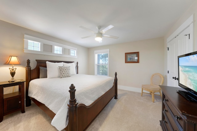 bedroom featuring light colored carpet, multiple windows, and ceiling fan