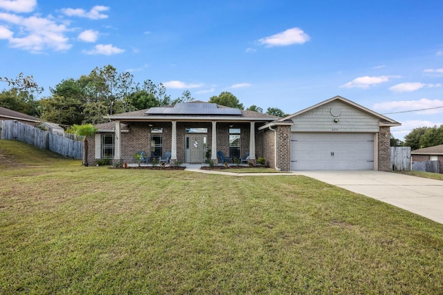 view of front facade with covered porch, a front lawn, a garage, and solar panels