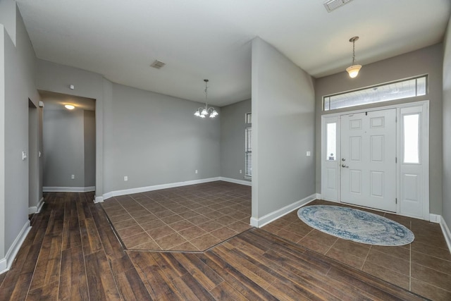 foyer entrance featuring dark hardwood / wood-style flooring and a notable chandelier