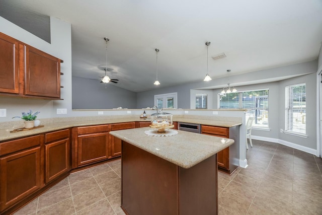 kitchen featuring a center island, hanging light fixtures, kitchen peninsula, light tile patterned floors, and ceiling fan with notable chandelier