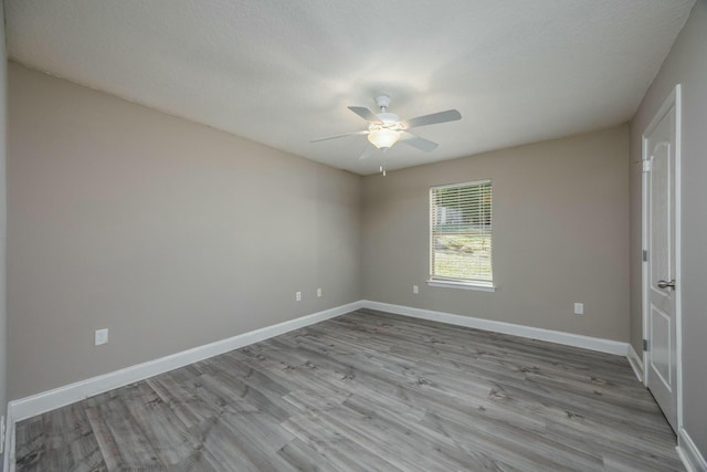 spare room with ceiling fan, light hardwood / wood-style floors, and a textured ceiling