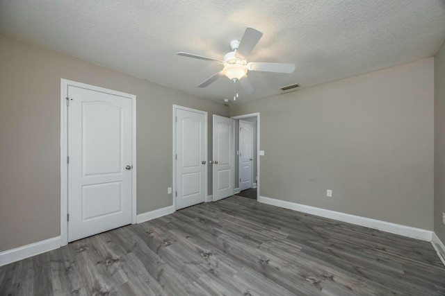 unfurnished bedroom with ceiling fan, a textured ceiling, and hardwood / wood-style flooring