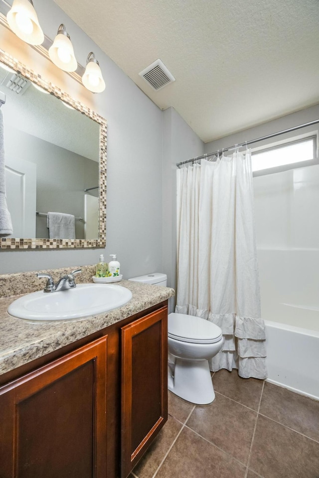 full bathroom with a textured ceiling, vanity, shower / bathtub combination with curtain, tile patterned flooring, and toilet