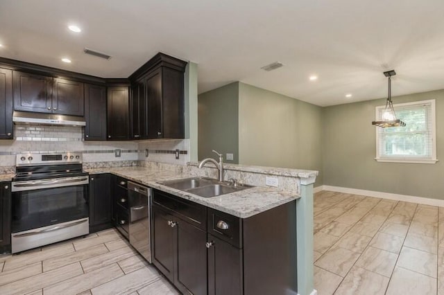 kitchen featuring kitchen peninsula, light stone countertops, stainless steel appliances, sink, and decorative light fixtures