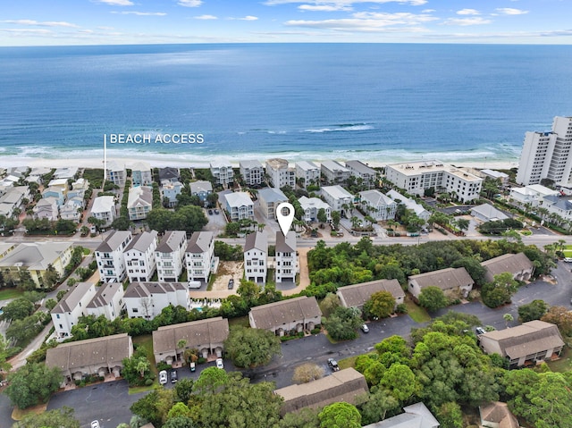 birds eye view of property with a water view and a beach view