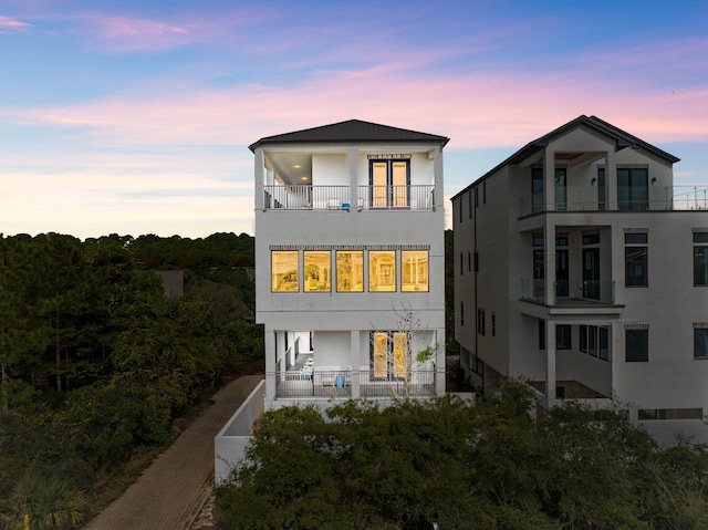 32 Cote Dazur Dr, Santa Rosa Beach, FL 32459 - back of property at dusk featuring a balcony and stucco siding
