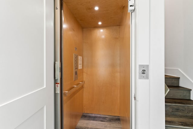 interior details with wood ceiling, hardwood / wood-style flooring, and elevator