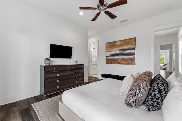 bedroom featuring dark hardwood / wood-style floors, ensuite bath, and ceiling fan