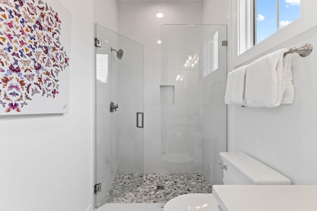 bathroom featuring an enclosed shower and toilet