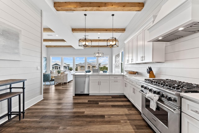 kitchen featuring premium range hood, white cabinetry, hanging light fixtures, appliances with stainless steel finishes, and dark hardwood / wood-style floors