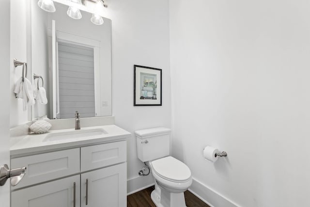 bathroom featuring vanity, hardwood / wood-style floors, and toilet