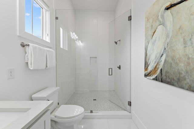 bathroom with vanity, toilet, a shower with shower door, and tile patterned floors