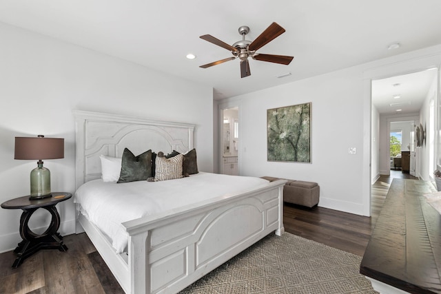 bedroom featuring ceiling fan, ensuite bathroom, and dark hardwood / wood-style flooring