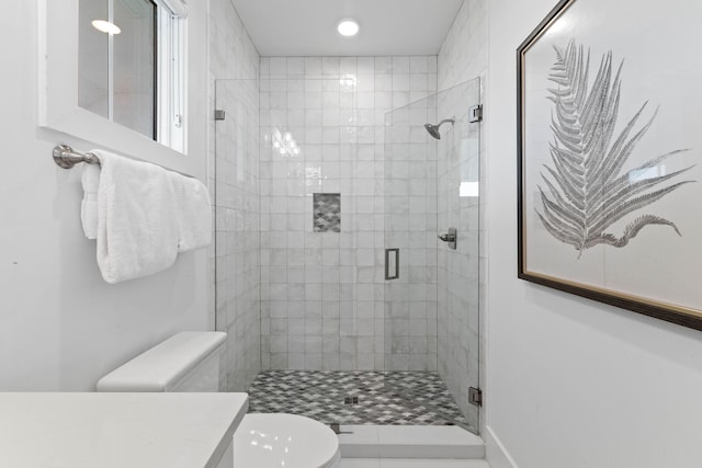 bathroom featuring vanity, an enclosed shower, and toilet