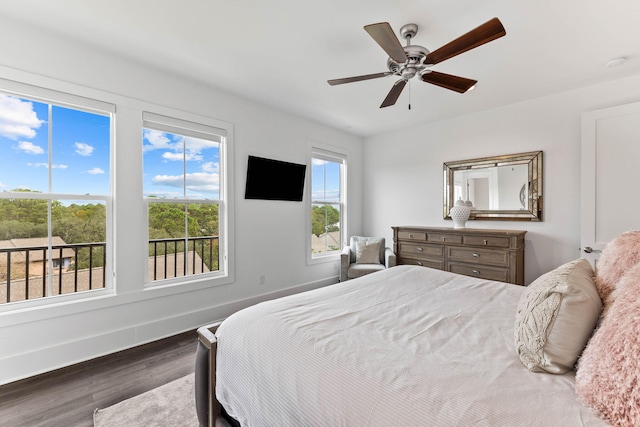 bedroom featuring ceiling fan, multiple windows, and dark hardwood / wood-style floors