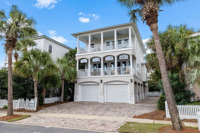 beach home with ceiling fan, a garage, and a balcony