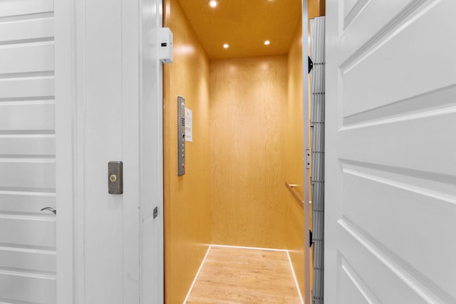 interior details with hardwood / wood-style flooring and elevator