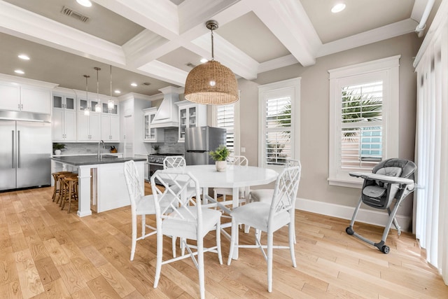 dining area featuring beamed ceiling, light hardwood / wood-style floors, ornamental molding, and coffered ceiling